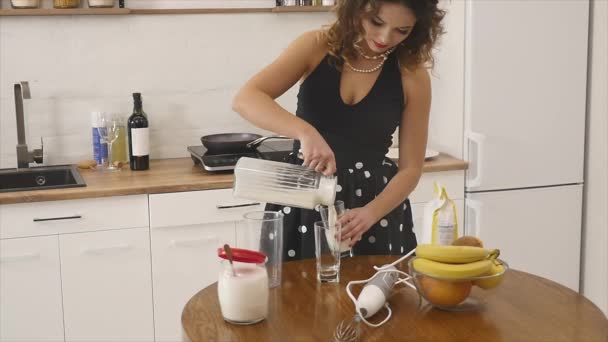 Giovane donna prepara impasto mescolando ingredienti nella ciotola utilizzando frusta in cucina. Cibo fatto in casa. Colpo di rallentamento — Video Stock