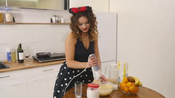 Mujer joven prepara masa mezclando ingredientes en el tazón usando batidor en la cocina. Comida casera. Disparo en cámara lenta — Vídeos de Stock