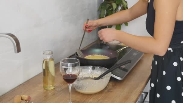 Μαγειρική τις τηγανίτες στο τηγάνι. Μαγειρική τις τηγανίτες σε ένα τηγάνι. Η γυναίκα αναστρέφει την τηγανίτα στο τηγάνι. Μαγειρικές τέχνες. Μαγείρεμα — Αρχείο Βίντεο