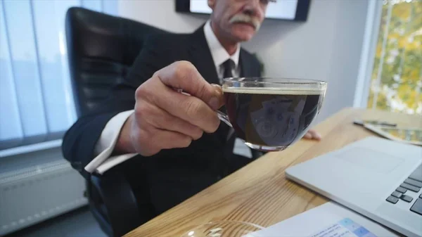 Бизнесмен пьет кофе во время просмотра экрана ноутбука — стоковое фото
