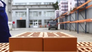 Yakın çekim: işçi tuğla depoda ayarlar