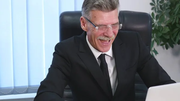 Tired businessman with laptop falling asleep in office — Stock Photo, Image