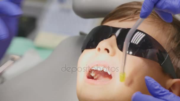 Niño paciente sentado en silla dental en consultorio de dentistas pediátricos — Vídeo de stock