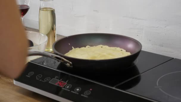 Koken pannenkoeken in een pan. Koken pannenkoeken in een koekenpan. De vrouw draait de pannenkoek in de pan. Culinaire kunsten. Koken — Stockvideo