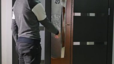 Bir adam dükkanı bir kapı kilidini açar.