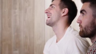 Arkadaşlar bir barda bir spor oyunu izlerken ve bir skora tezahürat. 4 k Uhd vurdu .