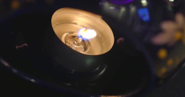 Ένα καίγοντας tealight στο σκοτάδι, κινηματογράφηση σε πρώτο πλάνο — Αρχείο Βίντεο