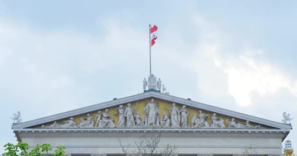 Rakouská vlajka na dům parlamentu ve Vídni, štítem na pozadí modré oblohy — Stock video
