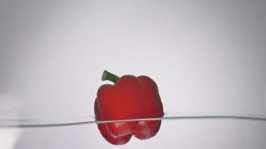 Stüdyo su sıçrama içinde akvaryum beyaz zemin üzerine kırmızı biber vurulmuş