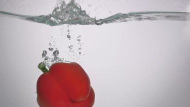 Stüdyo su sıçrama içinde akvaryum beyaz zemin üzerine kırmızı biber vurulmuş