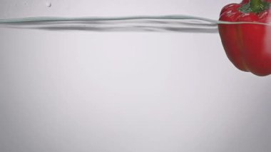 Stüdyo su sıçrama içinde akvaryum beyaz zemin üzerine kırmızı biber vurulmuş