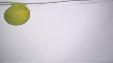 Beyaz arka plan üzerinde düşen suya limon vurdu