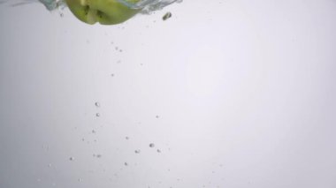 Elma yarısı üzerinde beyaz arka plan suya düşer