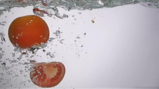 Томатне падіння у воді бризки з бульбашкою — стокове відео