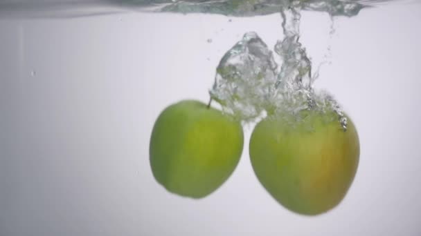 Manzanas que caen en el agua en el acuario — Vídeo de stock