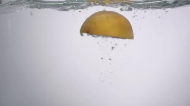 Hälfte der Grapefruit fällt ins Wasser — Stockvideo