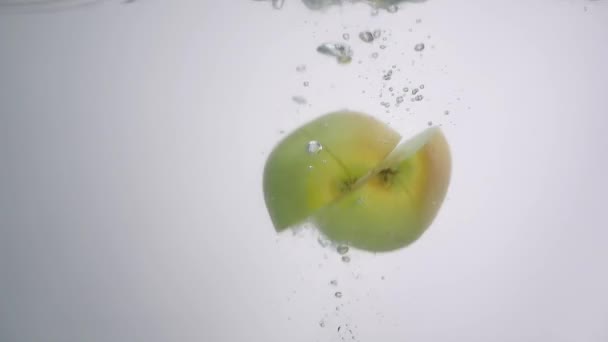 La moitié des pommes tombe dans l'eau sur fond blanc — Video