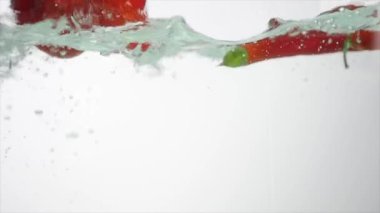 Stüdyo su sıçrama içinde akvaryum beyaz zemin üzerine kırmızı biber vurulmuş