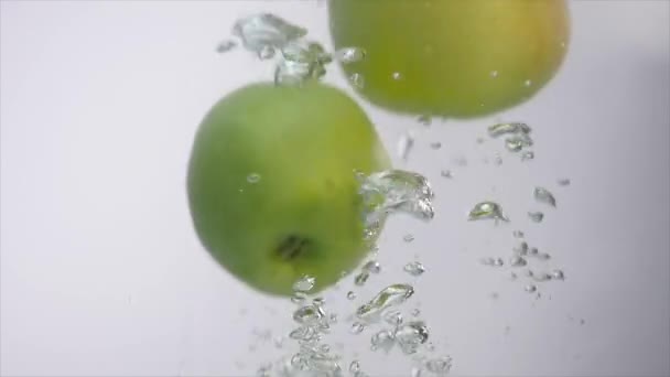 Яблоки, падающие в воду в аквариуме — стоковое видео