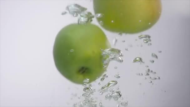 Manzanas que caen en el agua en el acuario — Vídeo de stock