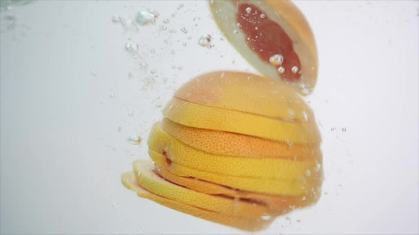 Fruta fresca en agua salpicada, toronja que cae — Vídeos de Stock