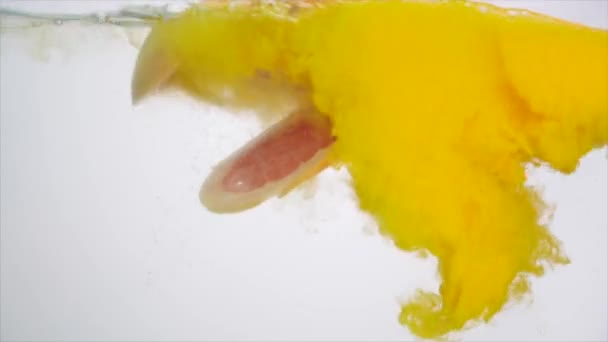 Frutta fresca in acqua con gocciolamento giallo, pompelmo cadente — Video Stock