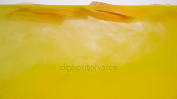 Frutta fresca in acqua con gocciolamento giallo, pompelmo cadente — Video Stock