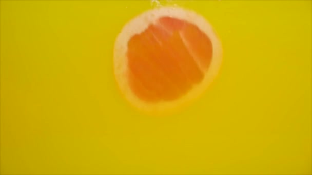 Frisches Obst in Wasser mit gelbem Gliederspritzer, fallende Grapefruit — Stockvideo