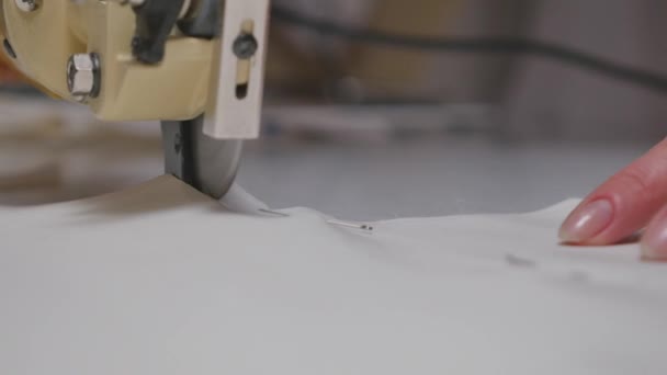 Mulher cortando um pedaço de pano à mesa no estúdio de moda. close-up — Vídeo de Stock