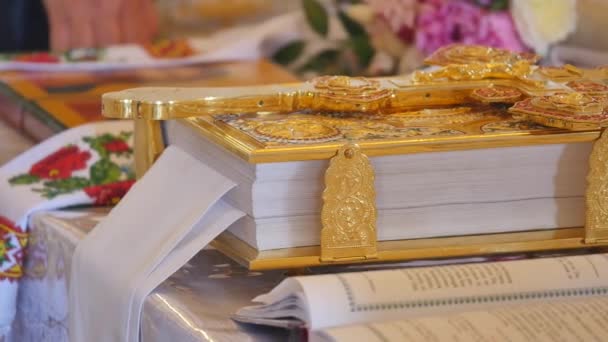 Gouden orthodoxe kruis en kerkboek close-up — Stockvideo