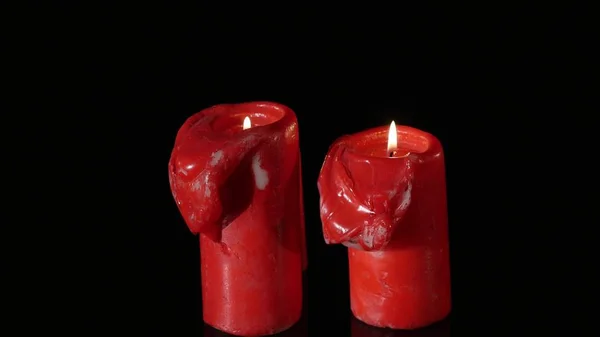 Закройте 3 зажженных красных свечи, вращающихся вокруг черного фона — стоковое фото