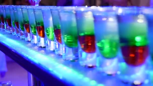 Grupo de pequenas garrafas coloridas. Coquetéis alcoólicos, licores na mesa branca — Vídeo de Stock
