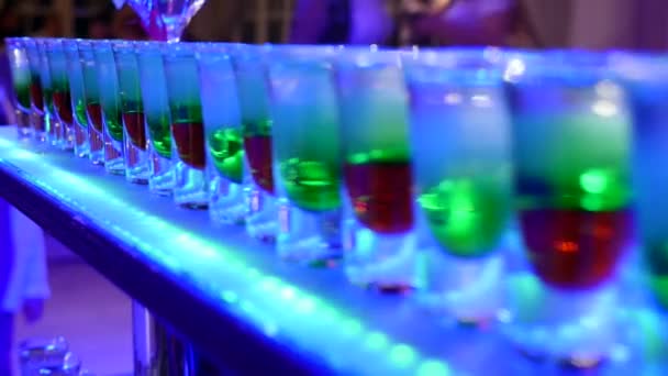 Groupe de petites bouteilles colorées. Cocktails alcoolisés, liqueurs sur la table blanche — Video