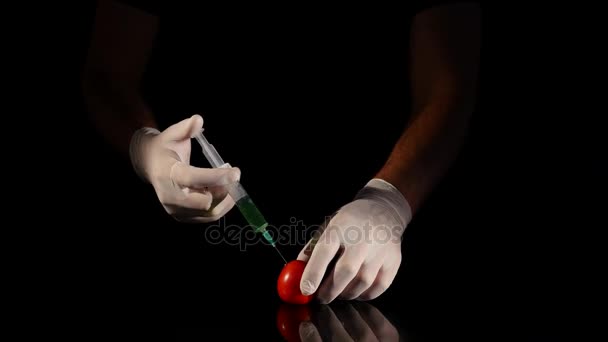 Mains de scientifiques mâles avec seringue injectant de la substance dans la tomate — Video