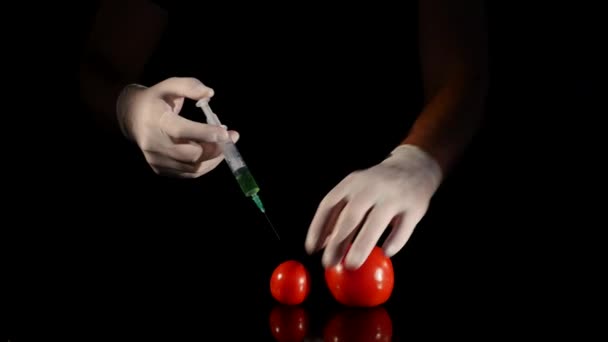 Mãos masculinas de cientista com seringa injetando substância no tomate — Vídeo de Stock