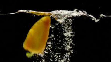 Sarı tatlı biber, capsicum annuum, siyah arka plan suya düşen sebze