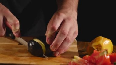 Patlıcan patlıcan, taze sebze arkasında kesme eller mans. Erkek el patlıcan ızgara için dilimleme. Adam mutfakta Sebze Doğrama