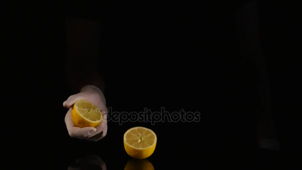 Mano spremitura limone su sfondo scuro — Video Stock