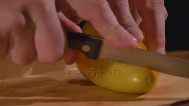 Ένα χέρι μάγειρες κόβει μια πιπεριά με ένα μαχαίρι σε ένα ξύλο κοπής — Αρχείο Βίντεο