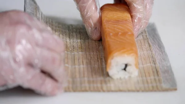 Närbild av kock händer förbereda japansk mat att göra sushi på restaurang. Ung kock som serverar traditionella moderna japan måltid i industriella kök. Närbild skytte vapen av cook-kocken att göra rullar — Stockfoto