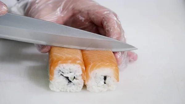 Chef en restaurante preparando y cortando rollos de sushi comida saludable —  Fotos de Stock
