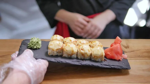 Крупный план - официант положил суши на стол в ресторане — стоковое фото