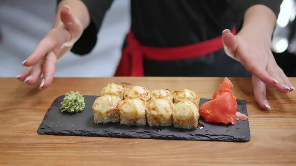 Крупный план - официант положил суши на стол в ресторане — стоковое фото