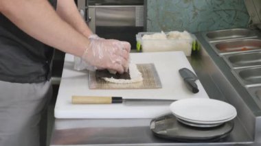 Eller uzun suşi rulo yapmak. Beceri gösteren suşi şefi. Ünlü Japon çanak. Üstten Görünüm