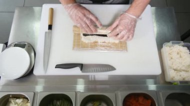 Eller uzun suşi rulo yapmak. Beceri gösteren suşi şefi. Ünlü Japon çanak. Üstten Görünüm