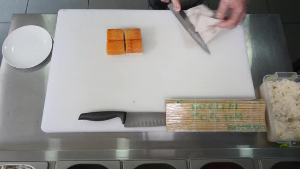 Chef in ristorante preparare e tagliare sushi rotoli di cibo sano. vista dall'alto — Video Stock