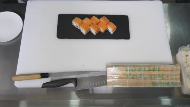 Professioneller Koch, der in der Restaurantküche asiatische Speisen und Sushi zubereitet und zubereitet. Ansicht von oben — Stockvideo