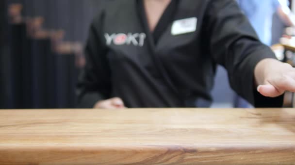 Primo piano - il cameriere mette il sushi a bordo sul tavolo del ristorante — Video Stock