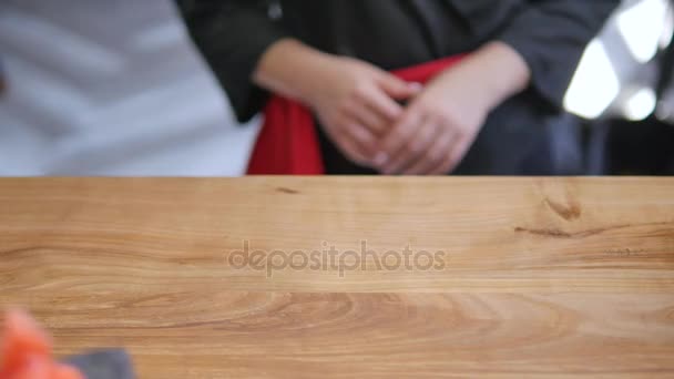 Close-up - the waiter put the sushi on board on the table in restaurant — Stock Video