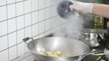 Asya restoran mutfak, yemek yemek, çalışma profesyonel aşçı olarak genç adam Şef